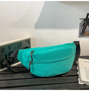 Detail of lime green nylon waist bag featuring smooth zipper and durable adjustable strap