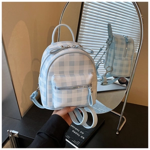 Détail d'un mini sac à dos à carreaux bleus avec poche zippée et sangles réglables