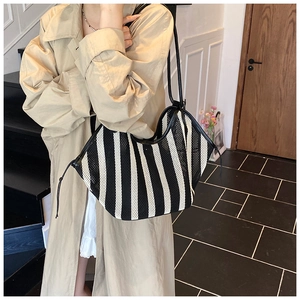 Detail of black and white striped mesh tote bag with leather trim and shoulder strap
