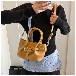 Détail du sac à main jaune moutarde avec boucle décorative et bandoulière amovible