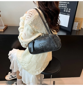Chic black vintage leather shoulder bag worn with a knit sweater for commuting