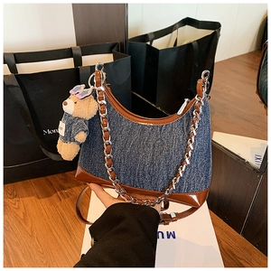 Λεπτομέρεια denim τσάντας με δερμάτινο φινίρισμα και διακοσμητικό αρκουδάκι