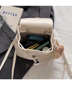 Détail intérieur du sac à dos beige à carreaux montrant le rangement des cosmétiques