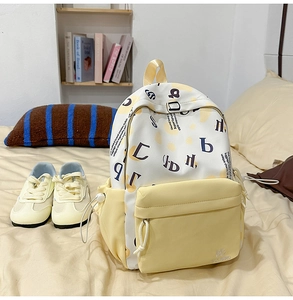 Dettaglio di uno zaino in tela crema e scarpe casual coordinate su un letto morbido