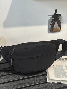 Minimalist black nylon crossbody waist bag with multi-zipper pockets and adjustable strap