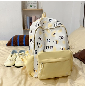 Dettaglio di uno zaino in tela giallo e bianco con stampe di lettere in camera da letto