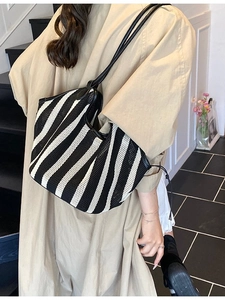 Large capacity black and white striped woven tote bag shown on a model for casual style