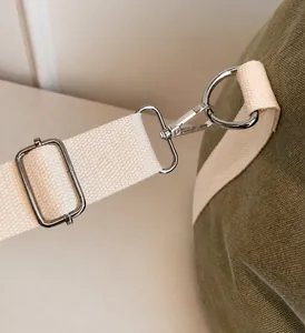 Close-up of deep green canvas bag featuring dark gunmetal hardware and durable straps