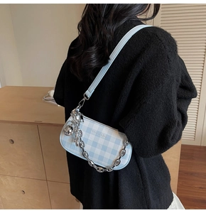 Detail of blue and white checkered underarm bag with silver chain and sphere pendant