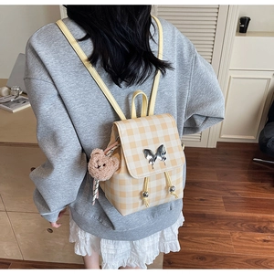 Détail du mini sac à dos à carreaux jaunes avec fermoir papillon argenté et petit ourson