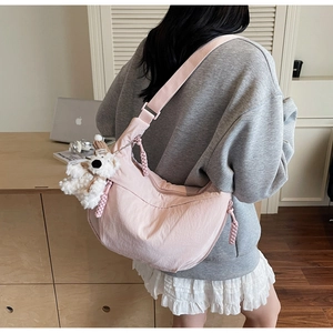 Pink large-capacity dumpling cross-body bag with cute bear charm shown on model