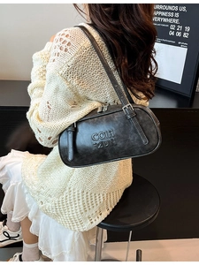 Retro charcoal leather shoulder bag with embossed letters shown on a female model