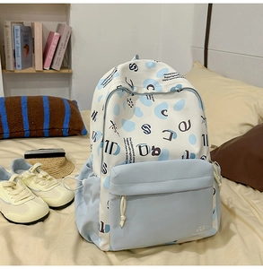 Vista dettagliata dello zaino GUIBIRD bianco e blu a pois in un ambiente scolastico
