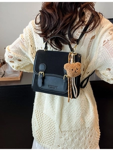 Fashionable black leather and suede backpack for women with a cute brown bear charm