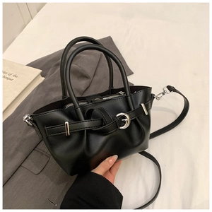 Détails de la boucle en métal argenté et texture mate de ce sac seau noir élégant