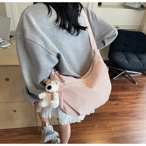 Pink crescent crossbody bag detail with cute white plush bear pendant on wide strap