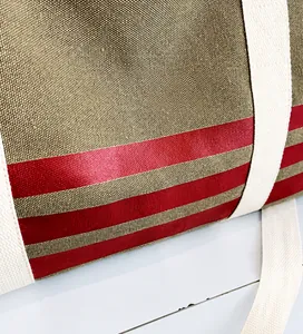 Detailed macro texture of heavy khaki canvas with red stripes on a large travel tote bag