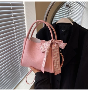 Pink bucket bag with lychee texture featuring a stylish plaid scarf and crossbody strap