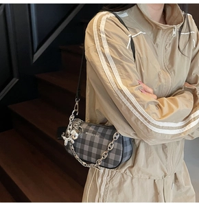 Detail of checkered shoulder bag with silver chain strap and balloon dog charm