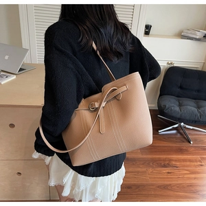 Detail of light brown lychee grain tote bag with white contrast stitching and buckle