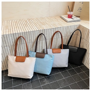 Detail showing high-quality fabric tote bags in beige, blue, grey, and black colors