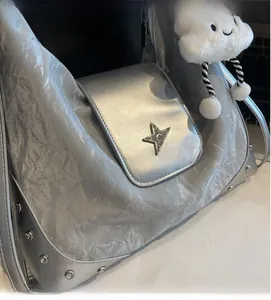 Detailaufnahme der silbernen Tasche mit Sternemblem, Nieten und Wolkenanhänger