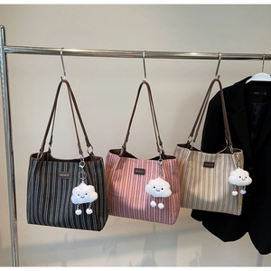 Detailed display of striped tote bags in three colors hanging on a display rack