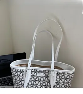 Close-up of stylish printed tote bag showing adjustable straps and satin interior lining
