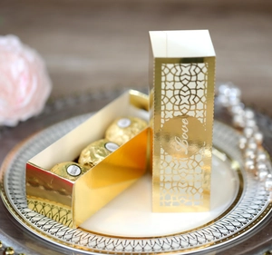 Nahaufnahme der goldenen lasergeschnittenen Bonbonschachtel mit Love-Schriftzug auf Teller