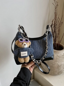 Retro τσάντα denim bucket με δερμάτινη επένδυση και μενταγιόν αρκουδάκι σε μίνιμαλ χώρο