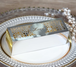 Makroaufnahme einer silbernen Laser-Cut Love Gastgeschenkbox mit Perlen