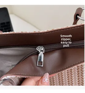 Macro shot of smooth silver metal zipper and brown leather piping on striped tote bag