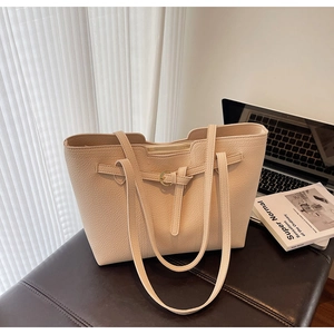 Detail of beige lychee grain leather tote bag with elegant gold ring hardware buckle