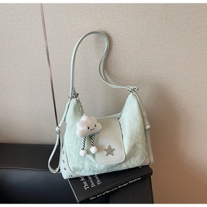 Detail view of mint green pleated tote bag with star logo and cloud plush pendant