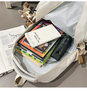 Spacious interior of white canvas backpack showing books, laptop and printed lining