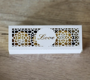 Makroansicht der weißen lasergeschnittenen Geschenkbox mit goldener Love-Schriftzug