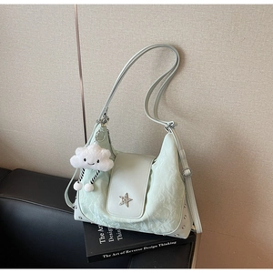 Details einer minzgrünen Tasche mit silbernem Stern und weißem Wolken-Anhänger