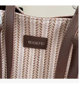Close-up of striped canvas tote fabric texture with premium leather brand logo patch