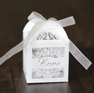 Detailed laser-cut white favor box featuring Love typography and a silky ribbon bow