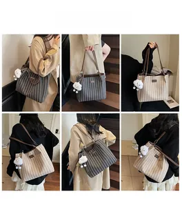 Detail view of large striped canvas tote bags with leather handles and plush cloud charms