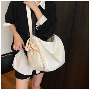 Detail of cream white tote bag with front zipper pocket and cute rabbit charm decoration