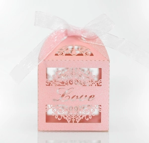 Detailed laser-cut pattern on pink gift box with Love lettering and white ribbon bow