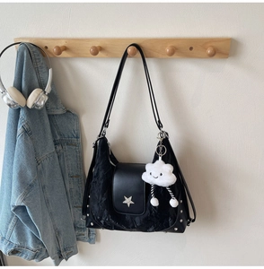 Detail of black crescent shoulder bag with silver star hardware and cloud plush charm