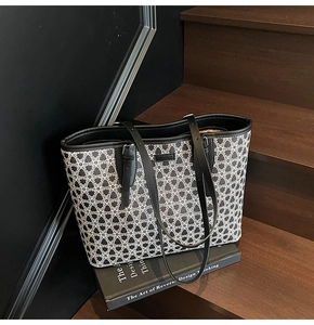 Detailed close-up of a large black and white butterfly pattern tote bag on classic books