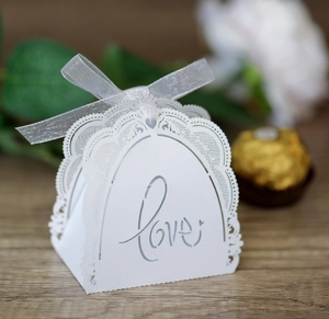 Detail of white lace wedding favor box with Love cutout and silver satin ribbon bow