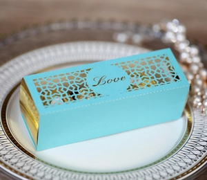 Nahaufnahme der lasergeschnittenen Love Hochzeitsbox in Blau und Gold auf feinem Porzellan