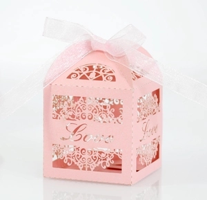 Detail of pink laser-cut wedding favor box with Love script and organza ribbon