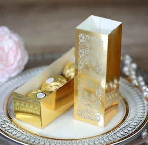 Detail of laser-cut gold wedding favor box with Love lettering and hollow pattern