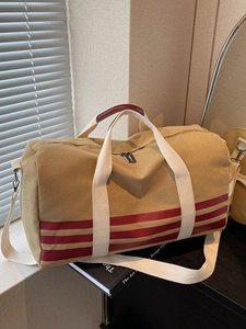 Khaki canvas travel duffel bag with red stripes and detachable shoulder strap