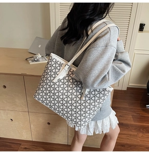 Detail view of large printed tote bag with leather straps and geometric pattern texture